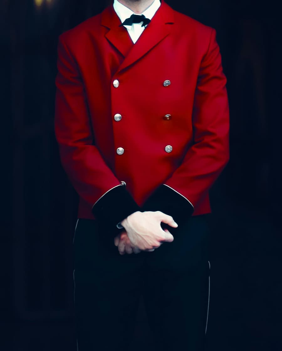 Concierge in a red uniform waiting at the door